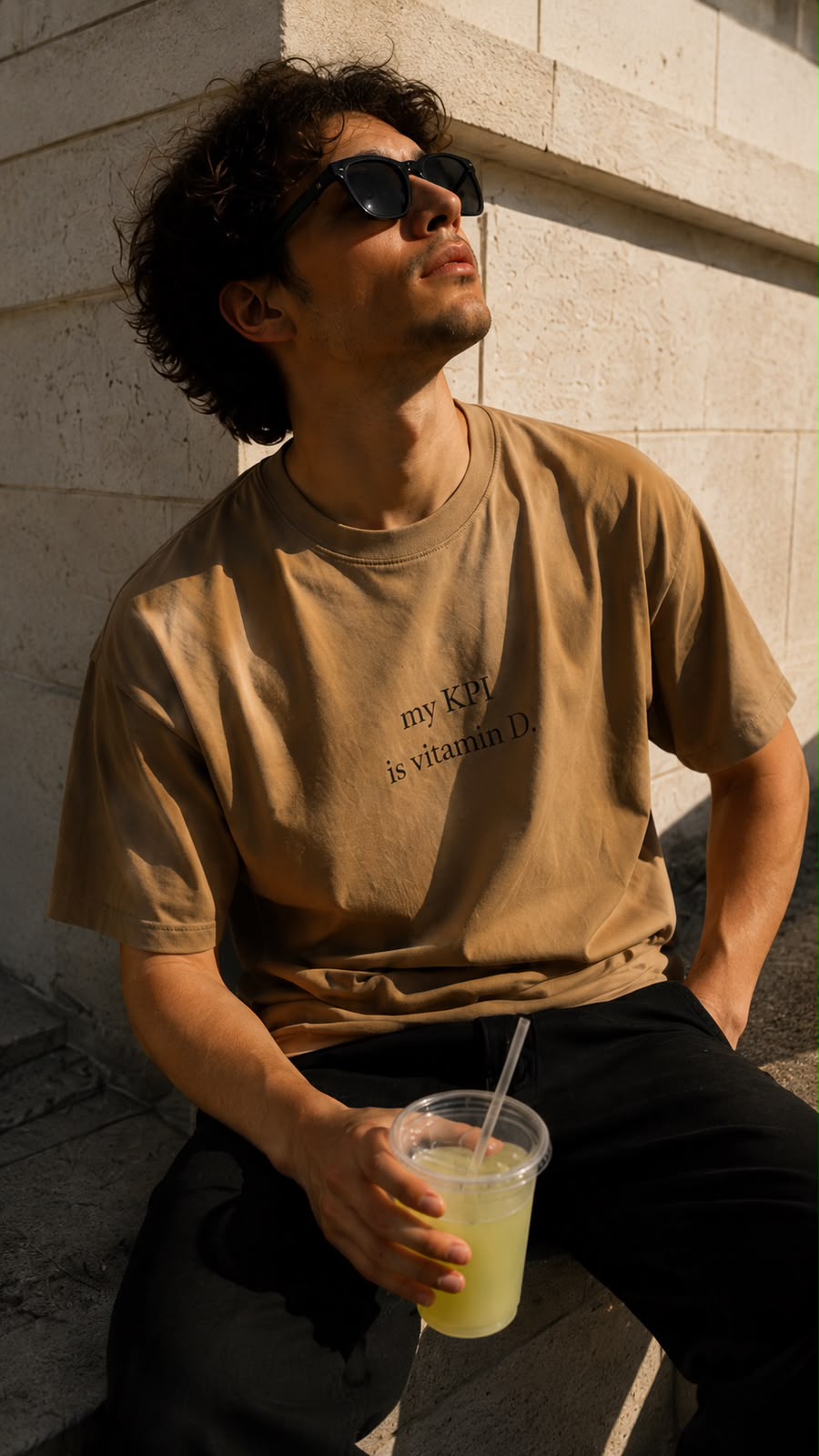 Man in the tan vitamin D tee sitting in the sun
