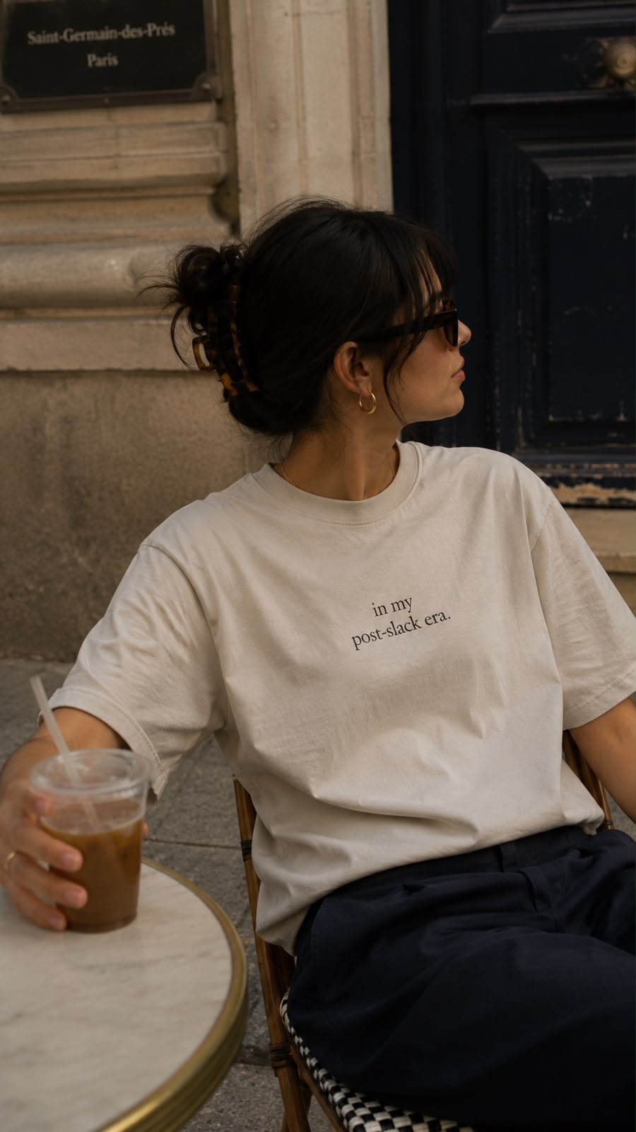Woman in the oat post-slack era tee at a Paris café